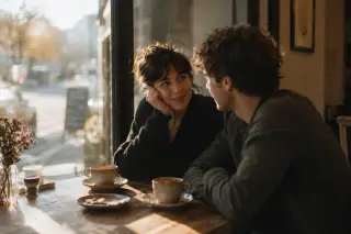 Couple at a café window table in warm late afternoon light