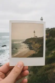 Hand holding a Polaroid print against the scene it shows